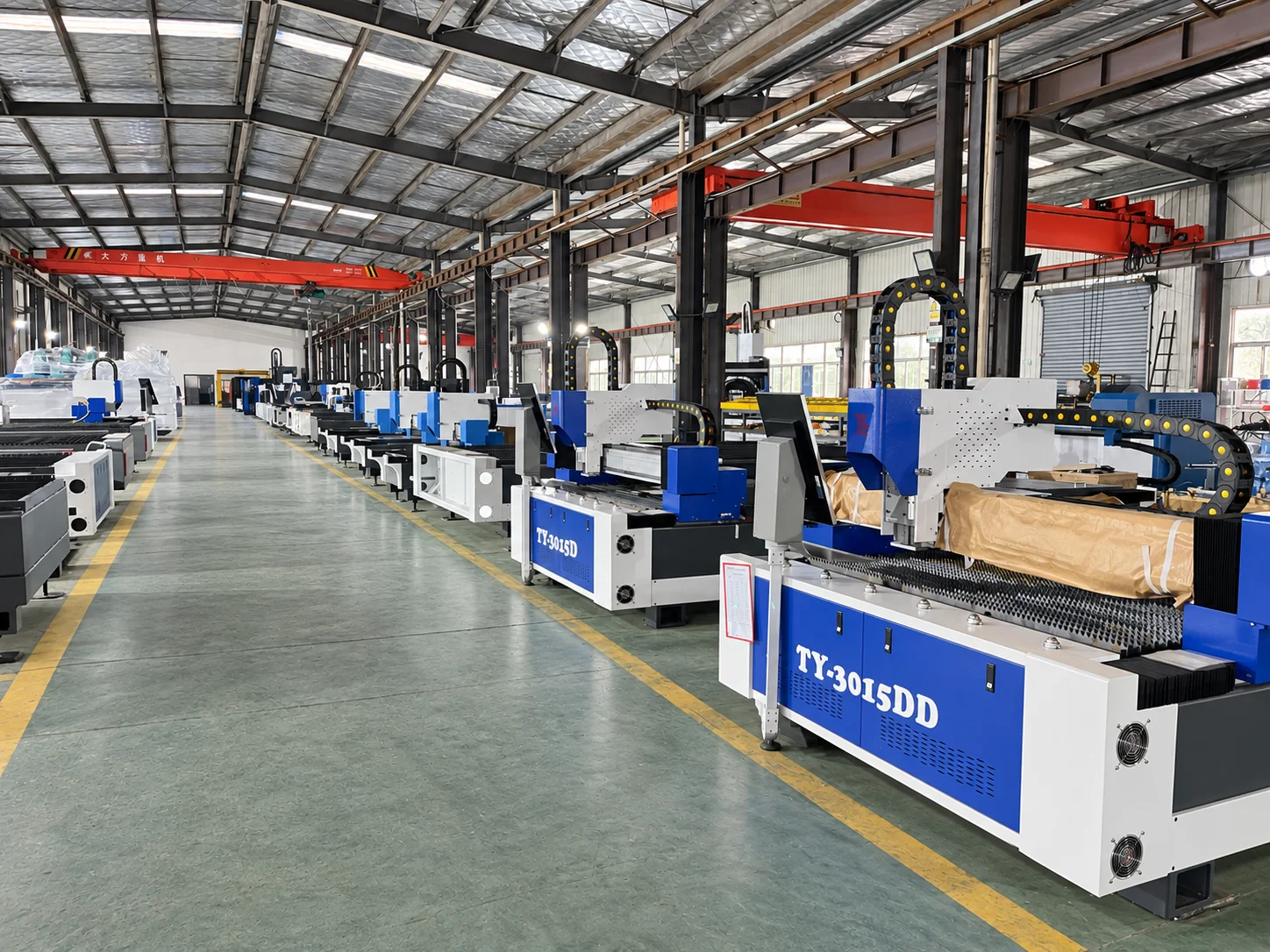 Rows of blue and white laser cutting machines inside the production workshop